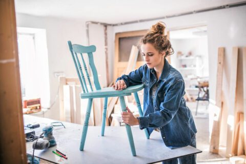 Woman creating a hand-crafted chair for her pop-up business