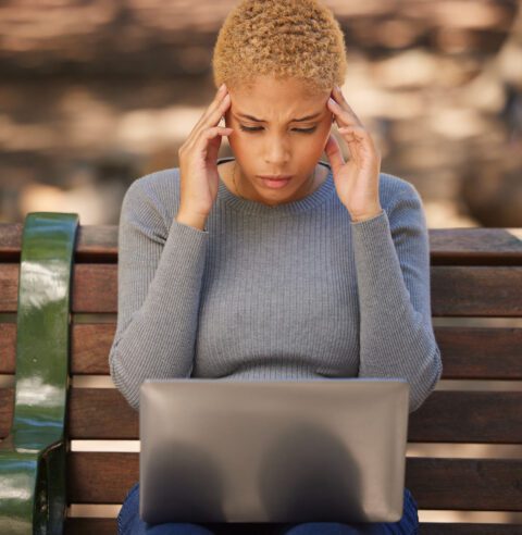 Woman looking at her computer, frustrated by the number of emails from you she’s received. 