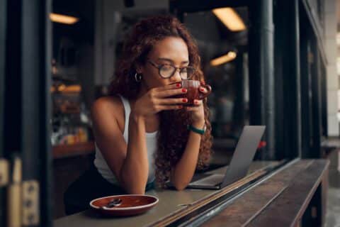 woman sipping coffee while working